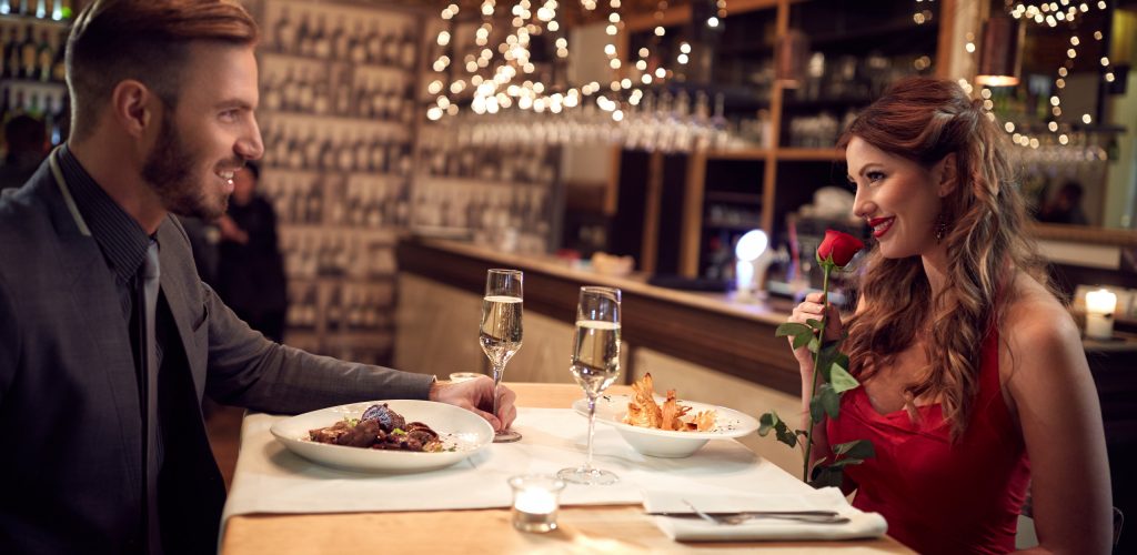 Romantic couple in love have dinner on Valentine’s evening in restaurant